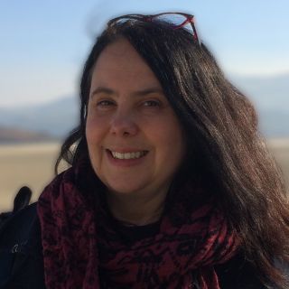 Color photograph of Angela Wright in front of a landscape.