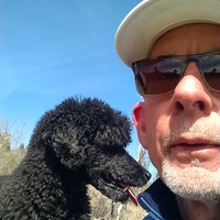 Color photograph of Bradford Mudge with a black poodle.