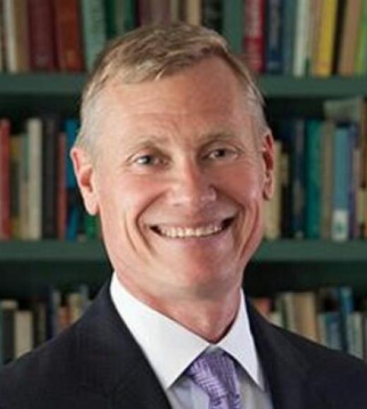 Color headshot of Carl Stahmer in front of a bookcase.