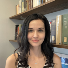Color headshot of Carmen Faye Mathes in front of a bookcase.