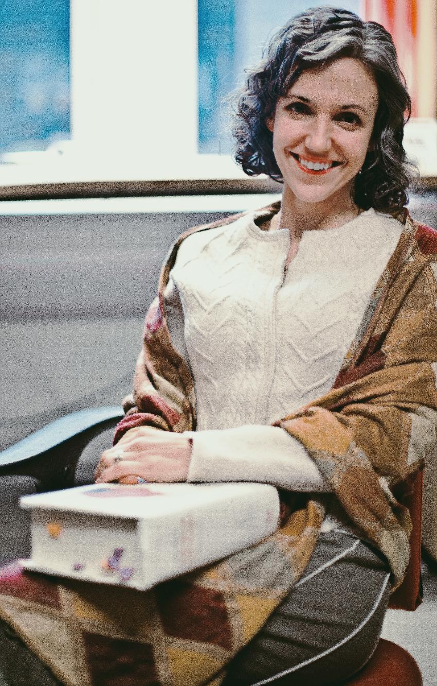 Color photograph of Cassandra Falke sitting down.