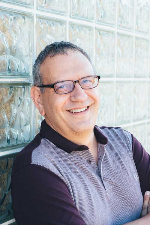 Color headshot of Charles Flowers in a polo and glasses.