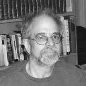 Black and white photo of Barry Silesky in front of a bookcase.