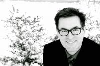 Black and white headshot of CC Wharram wearing glasses.