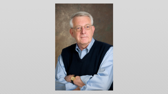 Color photograph of Charles Robinson in a blue shirt and navy blue sweater vest.