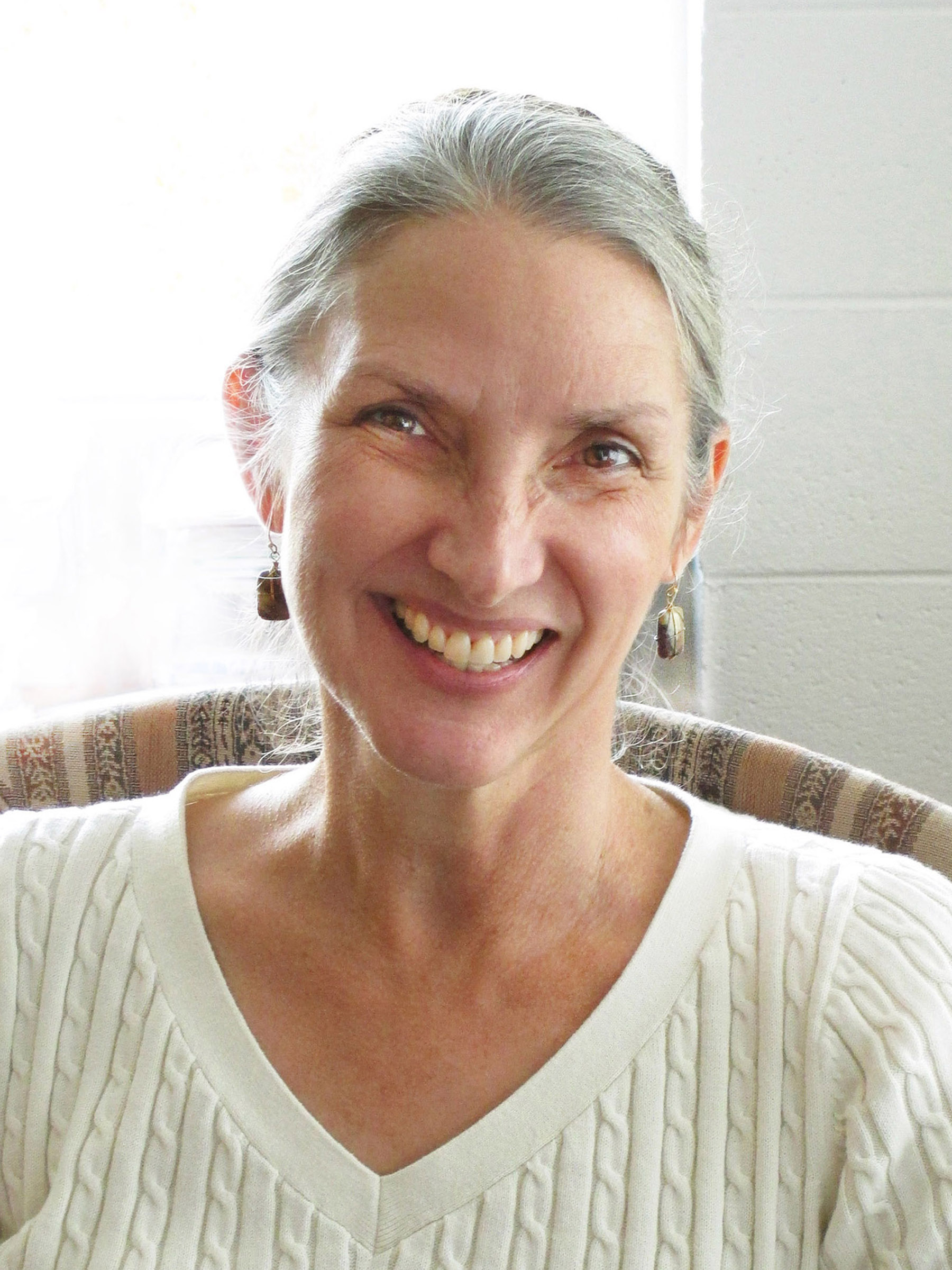 A color headshot of Dr. Anne Wallace wearing a cream sweater.